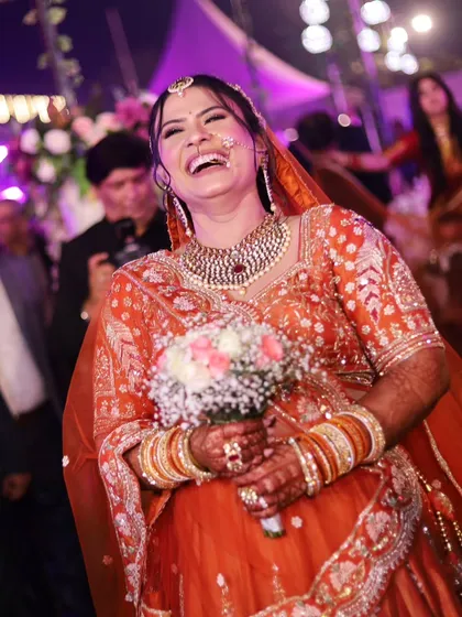 The pure, unadulterated laughter of the bride during her entrance. This candid shot is full of life and happiness.