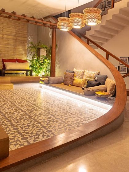 The curved wooden form elegantly separates the tiled puja area from the rest of the living space. The design is a bold, sculptural statement that is also deeply functional.