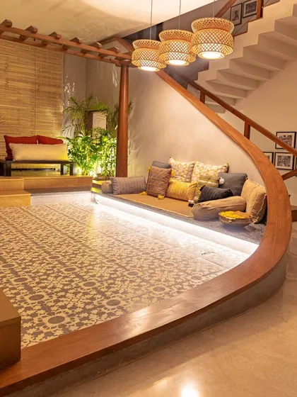 The curved wooden form elegantly separates the tiled puja area from the rest of the living space. The design is a bold, sculptural statement that is also deeply functional.