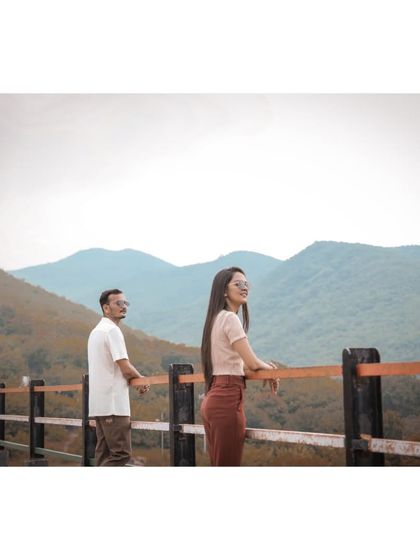 A couple enjoys a scenic mountain view from a lookout point during their casual and relaxed pre-wedding photoshoot.