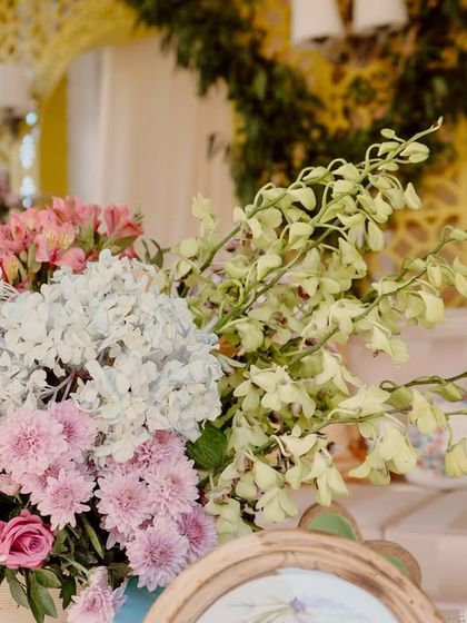 A lush floral arrangement of pink roses and hydrangeas, part of the pastel-themed lounge decor.