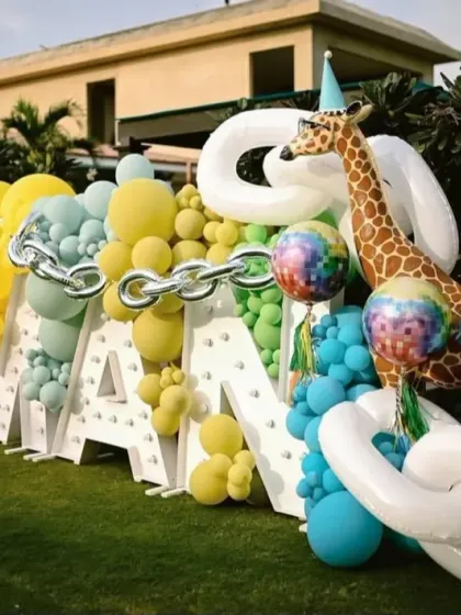 Another angle of the fun fair theme, showing the custom dessert cart and a tall giraffe prop, all part of a vibrant and playful first birthday party.