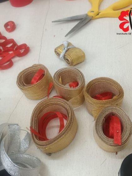 The little details matter. Here, we are preparing festive red and gold ribbons for our Christmas workshop, adding that perfect finishing touch to our students' creations.