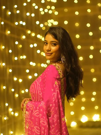 A joyful glance over the shoulder, surrounded by a wall of golden lights. This portrait is full of the festive spirit and happiness of Dev Deepawali.