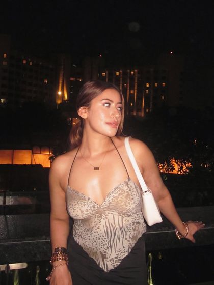 Looking out at the city lights in the animal print top and black skirt.