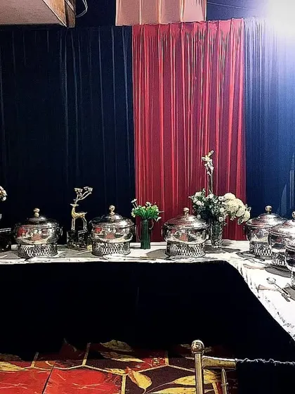 A dramatic black and red theme for a memorable evening. This U-shaped buffet setup for 100 guests was designed to be visually striking while offering easy access to a symphony of flavors.