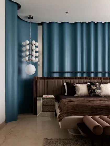 A close-up of the master bedroom's custom details. The blue ripple paneling, upholstered headboard, and statement pendant light come together to create a space that is both bold and serene.