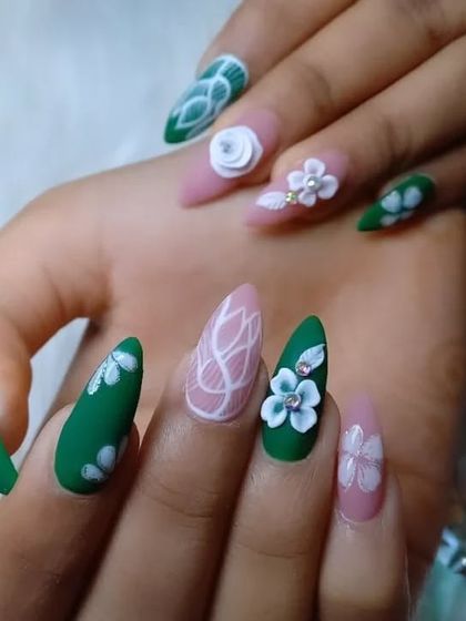 A creative mix of matte green and soft pink nails. This almond-shaped set includes 3D flowers, white line art, and floral paintings for a unique, garden-inspired look.