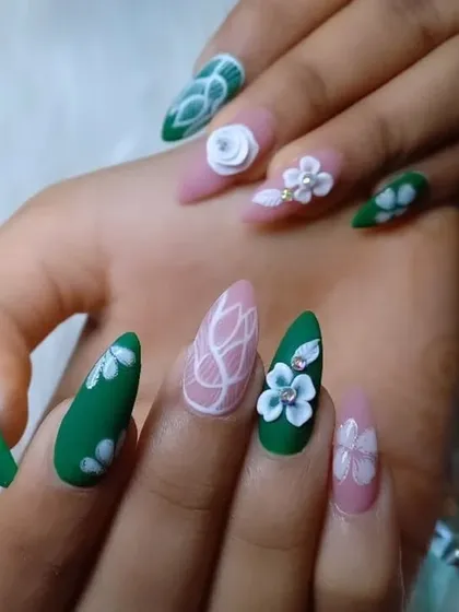 A creative mix of matte green and soft pink nails. This almond-shaped set includes 3D flowers, white line art, and floral paintings for a unique, garden-inspired look.