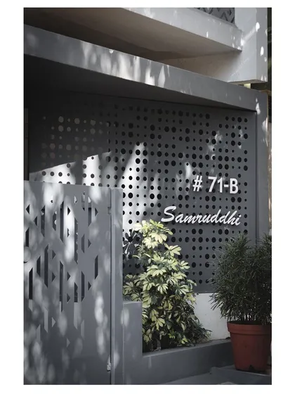 The perforated entrance gate and wall provide security while maintaining a sense of lightness and transparency.
