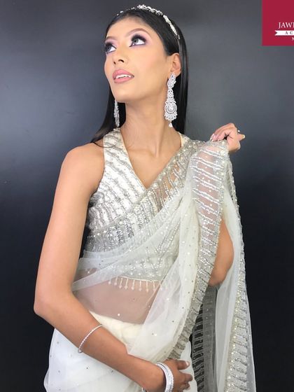 The model looks up, showcasing the full effect of the silver cut-crease and the elegant, sparkling saree.