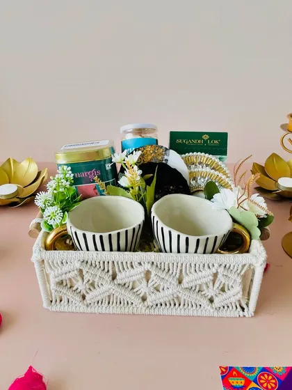 This premium macrame tray hamper includes gold-handled cups, gold-infused coasters, a T-light, tea, and snacks. It's one of my most in-demand items.