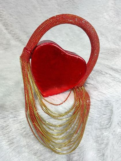 A close-up of the red heart fringe bag against a soft background, highlighting its vibrant color and sparkling fringe detail.