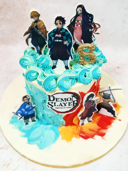 An angled view highlighting the action poses of the Demon Slayer characters and the textured, artistic frosting.