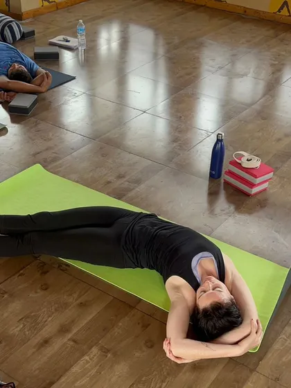 A student in a supported side-lying twist, a classic Yin pose for releasing tension in the spine and shoulders.