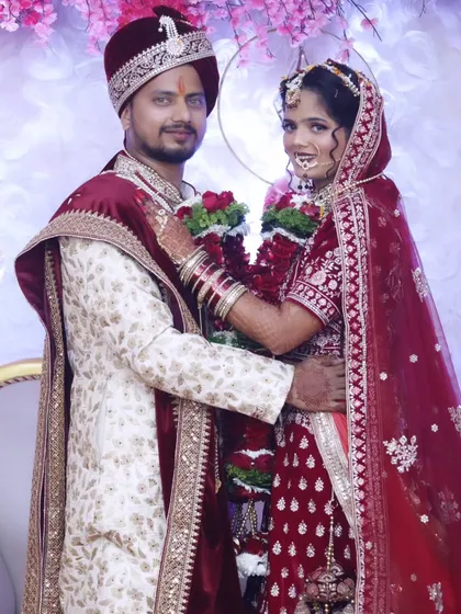 A classic portrait of a North Indian bride and groom in their coordinated wedding attire, showcasing a regal and timeless look.