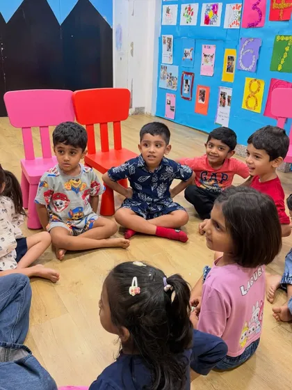 Children sit in a circle, fully engaged in a group activity. This setup encourages active participation and peer-to-peer learning.