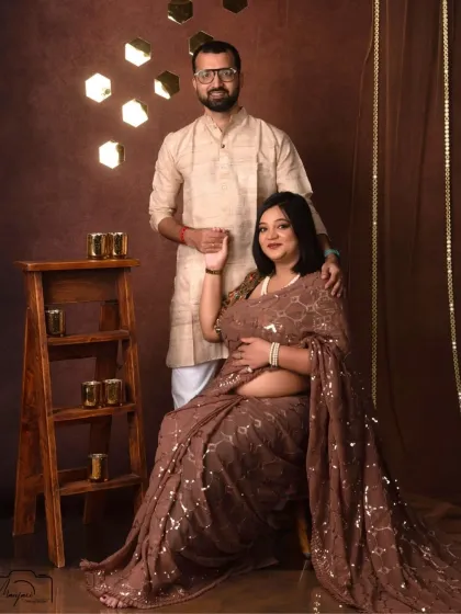 A regal seated portrait of the couple. The sequin saree and his traditional kurta create a sophisticated and glamorous look.