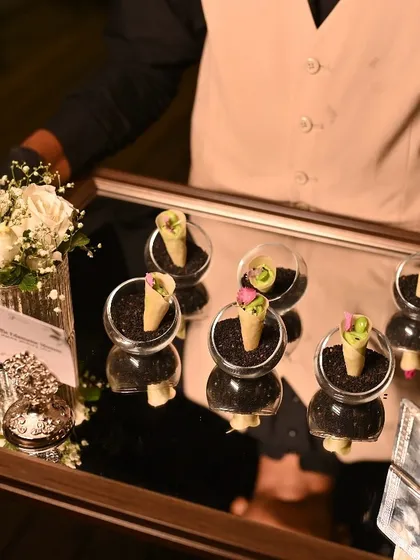 A tray of our creatively presented Truffle Edamame Mousse cones, served in glass bowls filled with black sesame "soil".