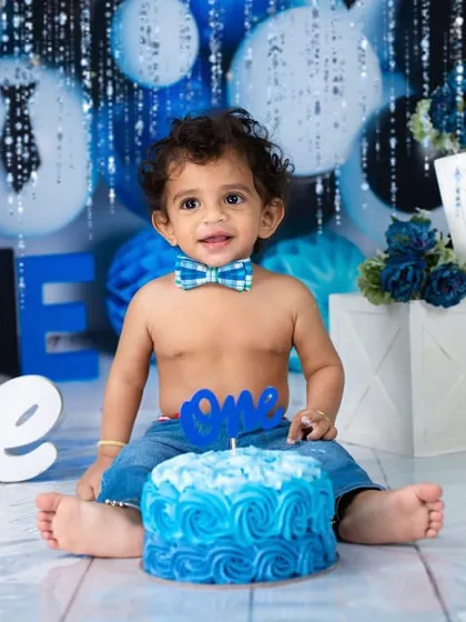 The official portrait before the smashing begins. This little gentleman is ready for his first birthday party in a stylish blue-themed setup.