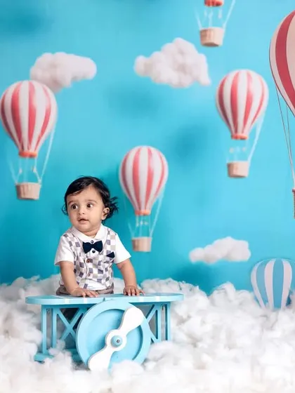 A 7-month-old baby boy ready for take-off in our hot air balloon and airplane-themed sitter session.
