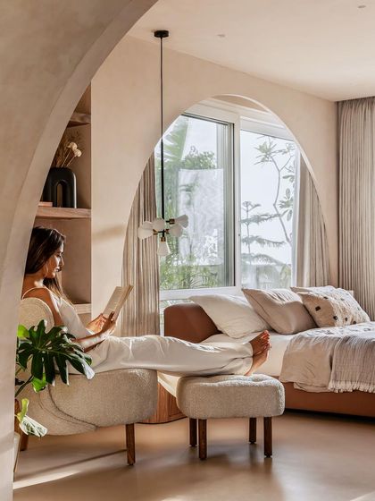 A quiet moment in the master bedroom, where arched openings and soft furnishings create a sense of peace and tranquility.