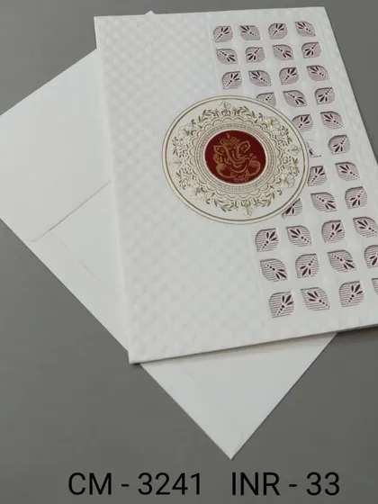 A modern white invitation with a geometric pattern and a central Ganesha emblem. This card is a great choice for those who want a blend of contemporary style and tradition.