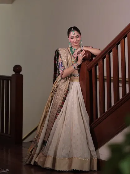 A final look at this royal aesthetic, with the bride posed gracefully by a staircase, showing off the beautiful fall of the lehenga.