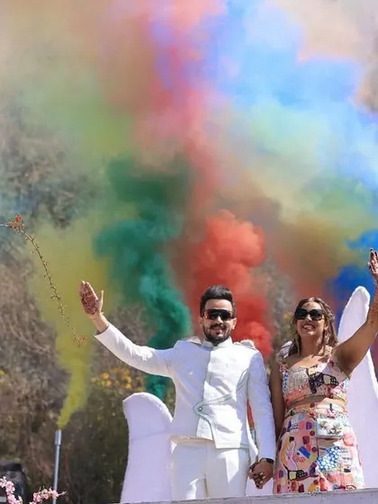The sheer joy of a grand entry. This shot shows the couple amidst a cloud of rainbow smoke, waving to their guests, perfectly capturing the celebratory spirit we aim to create.