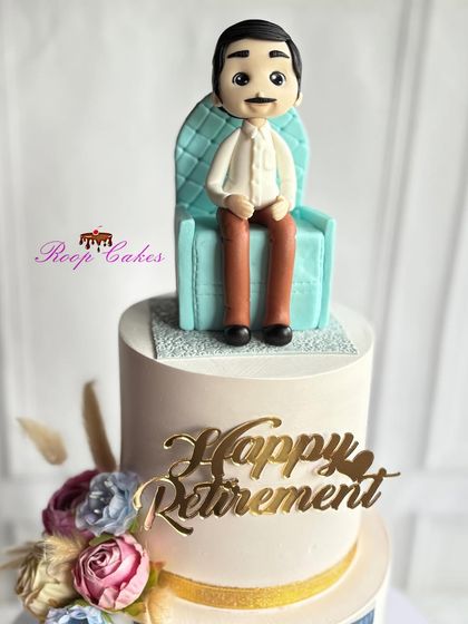 A close-up of the handcrafted fondant figure on the retirement cake. He's sitting comfortably in his chair, ready to enjoy a well-deserved rest after years of hard work.