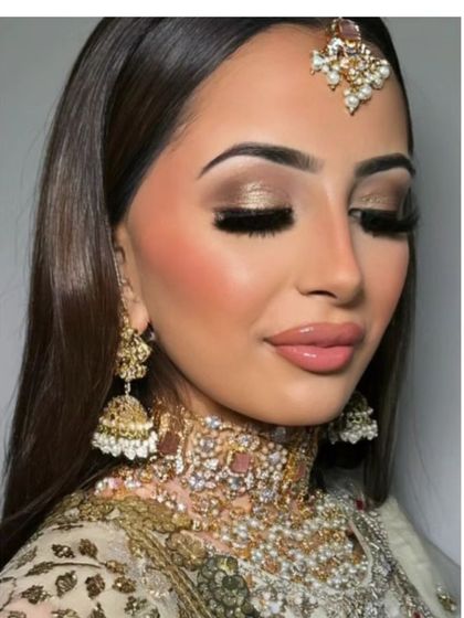 This golden glam look is perfect for a grand wedding reception. The focus is on shimmering gold eyeshadow, voluminous lashes, and a glossy nude lip for a truly luxurious feel.