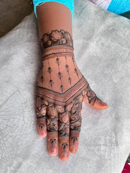 A close-up of the other hand, featuring a geometric pattern with hanging motifs, offering a modern twist on traditional designs.