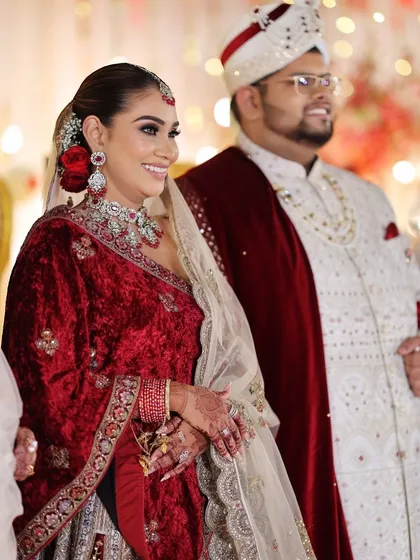 A beautiful shot of the couple, with the bride's radiant makeup and the red rose in her hair standing out.