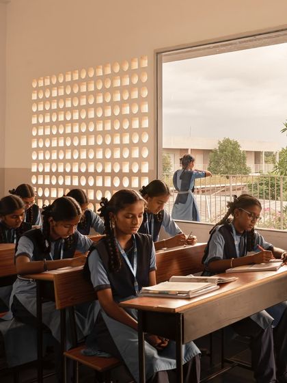 The classrooms are designed with large windows and jaali screens that allow for cross-ventilation and balanced natural light, creating a comfortable learning environment even in a hot climate.