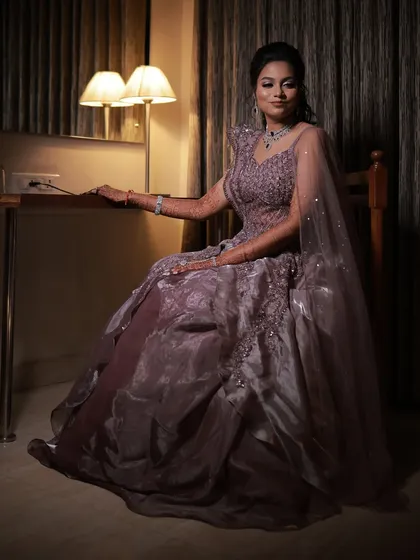 A full-length seated portrait, capturing the elegance of her sangeet gown and the soft, romantic hairstyle.