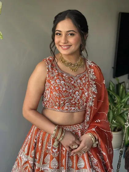 A full view of her Garba Night look. The makeup is soft and pretty, complementing her beautiful rust-colored lehenga.
