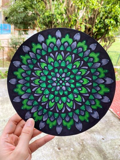 I explored shades of green and grey in this colored mandala on a black circular canvas. The blending of the colors gives the pattern a sense of depth and dimension.