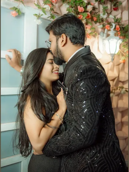 A close-up of a tender forehead kiss. This shot focuses on the affection and emotion between the couple, highlighted by the soft lighting and floral background.