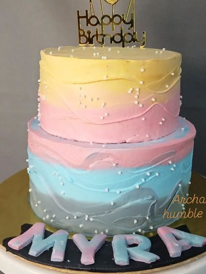 A two-tiered cake with a beautiful pastel watercolor effect.
