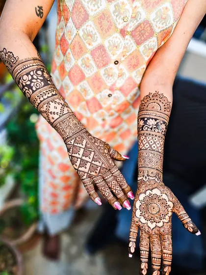 A beautiful design featuring a mix of mandalas on the palms and geometric patterns on the arms.
