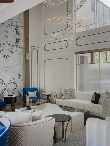 Another angle of the poolside living room, this shot shows the interplay of textures, from the quilted sofas to the smooth marble feature wall. The layout is intentionally open to create a sense of flow and visual connectivity across the different zones.