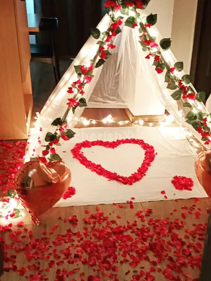 For a cozy and intimate surprise, I can set up a romantic canopy tent in your room. Decorated with fairy lights, flower vines, and a floor covered in rose petals, it creates the perfect private space for a proposal or anniversary.
