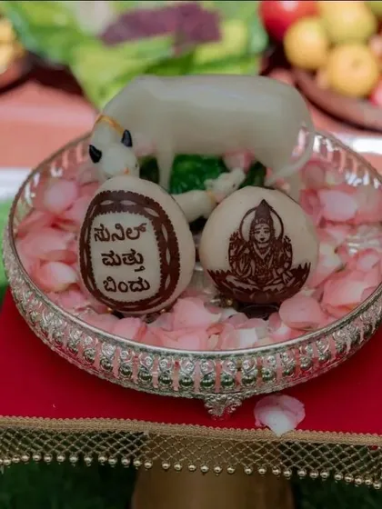 We add personal touches that make your event truly unique. Here you can see coconuts we custom-carved with a deity image and a welcome message in Kannada, placed in a silver tray with rose petals.