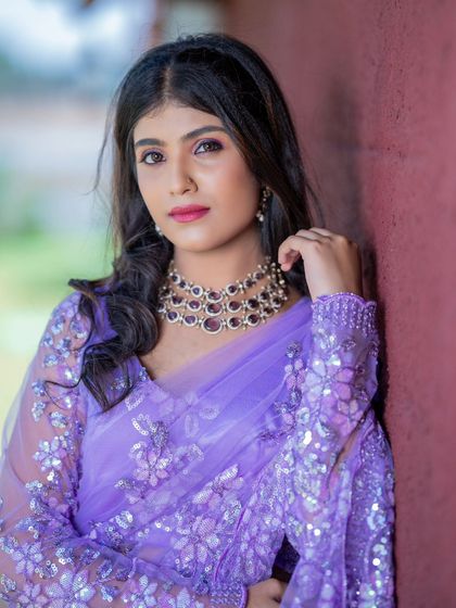 A model looking elegant in a lavender sequined saree, paired with a beautiful polki and amethyst necklace set.