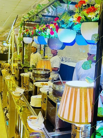 I use details like hanging floral baskets and elegant table lamps to add color and sophistication to my buffet presentations. It's about creating a feast for the eyes.