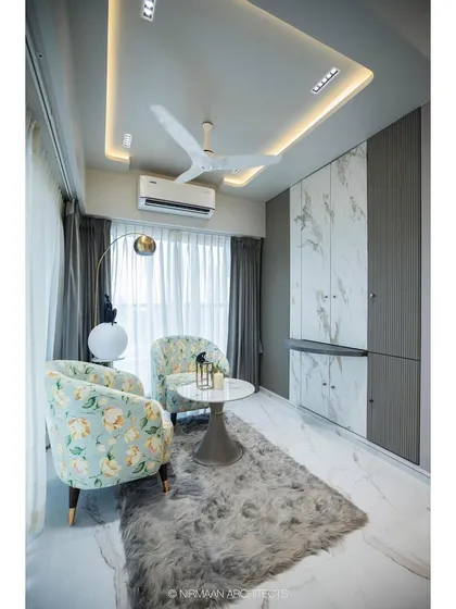 A formal seating area within a master suite, featuring two floral armchairs by the window. It's the perfect spot to enjoy the view and a quiet conversation.