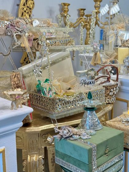 A close-up of the "Chandni Raatein" collection, highlighting the detailed acrylic and gold baskets, embellished boxes, and festive decor.