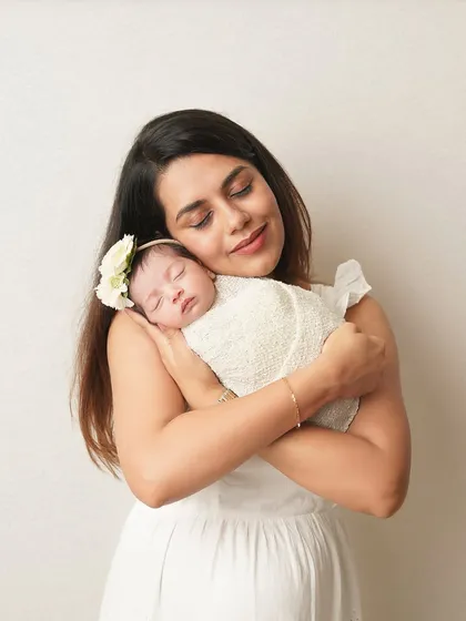 A mother's loving embrace. She holds her swaddled newborn, her expression full of peace and happiness. These are the quiet moments of motherhood I love to freeze.