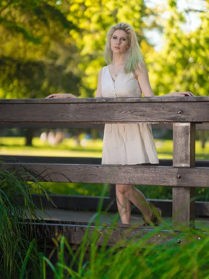 Using the lines of a wooden bridge to create leading lines and depth in this portrait. This composition adds an interesting structural element to an otherwise natural park setting, drawing the viewer's eye to the model.