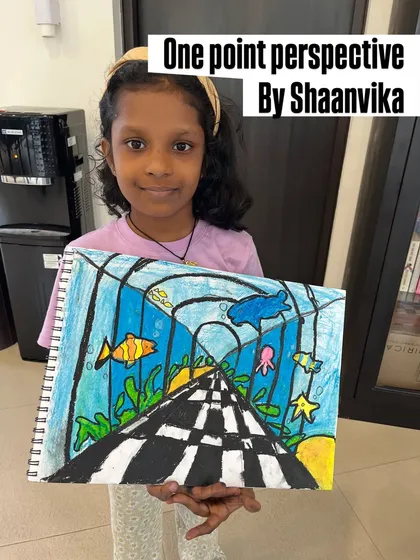 We also focus on teaching foundational art skills. Here, a proud student shows off her amazing one-point perspective drawing, learning how to create depth and space on paper.